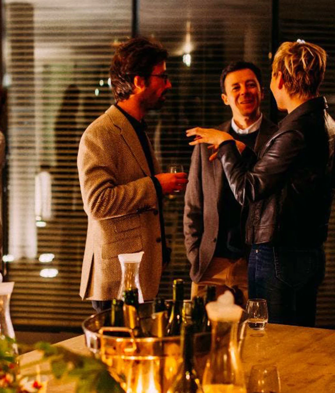 People socializing at evening indoor gathering.