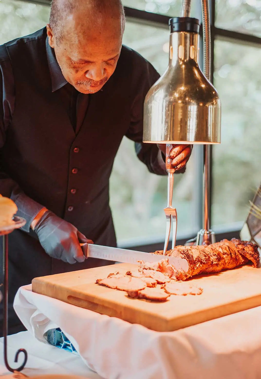 Chef slicing roasted meat at event
