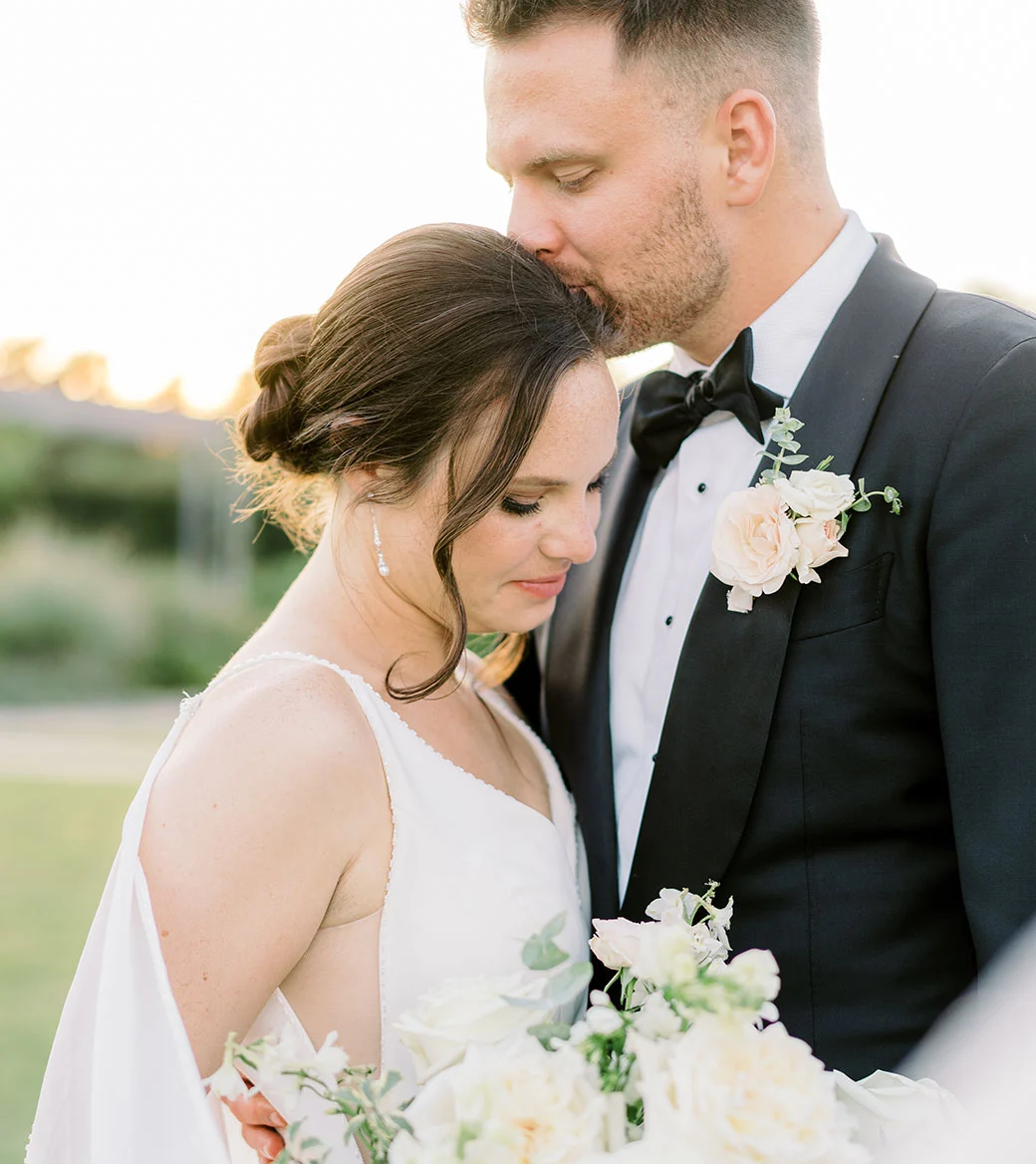 Wedding couple embracing in sunset light.