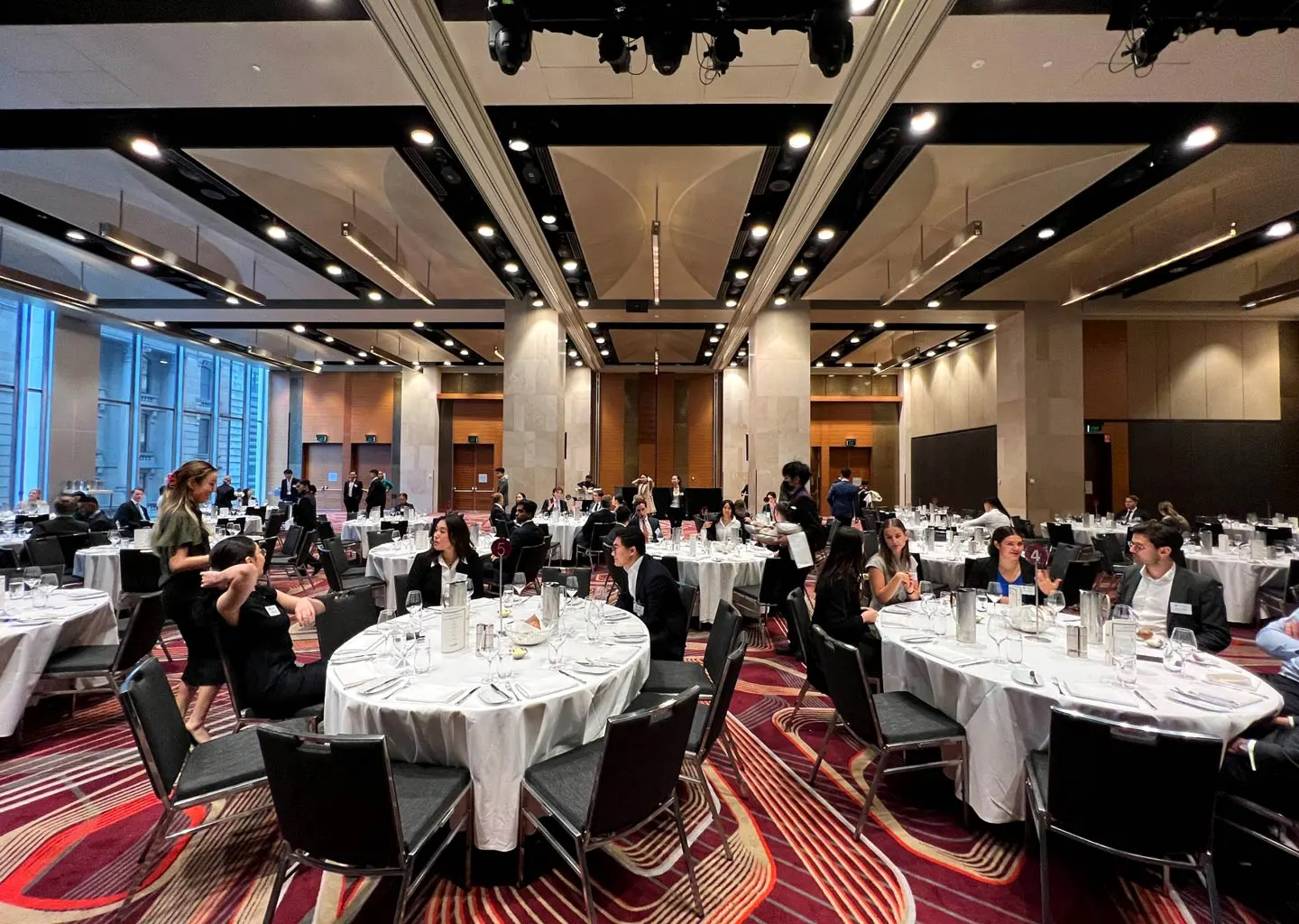 Conference room setup with attendees and tables.