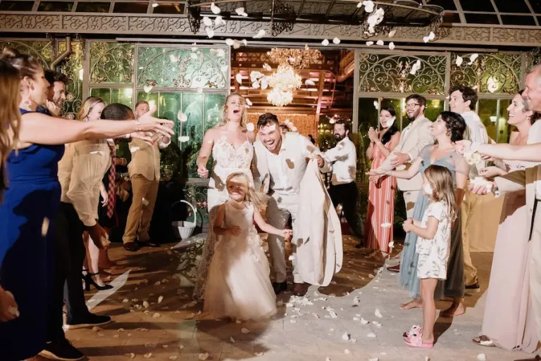 Bride and groom with guests throwing flower petals.