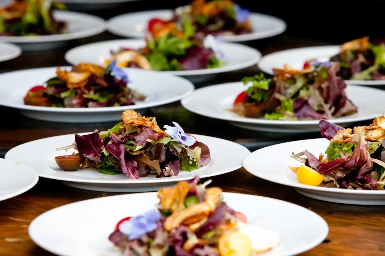 Plates with gourmet salads arranged neatly on table.