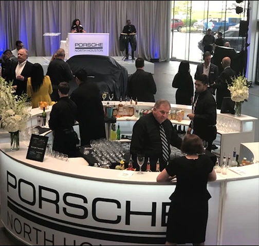 People at Porsche North Houston event with bar