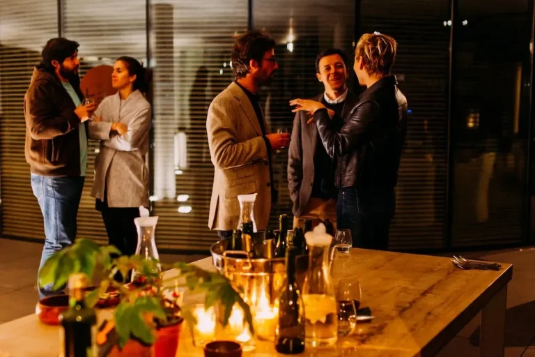 People conversing at a cozy evening gathering.